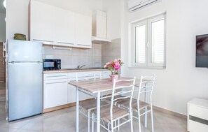 Enjoy meals in the kitchen with a microwave and dining area under a window.