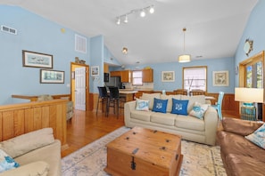 A spacious living area with a sofa, a coffee table, and a kitchen in the background.