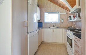 Compact kitchen with a refrigerator, sink, and stove, offering ample space for meal preparation.
