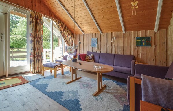 Relax in a warm and inviting space with a comfortable sofa set, wooden coffee table, and cushioned chairs.