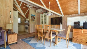 A cozy cabin interior with a dining area, kitchen, and living space.