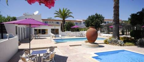 Una piscina al aire libre, una piscina climatizada