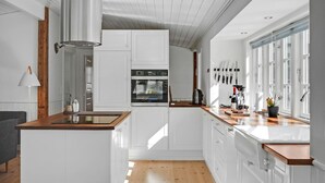 A modern kitchen with white cabinetry, wooden countertops, and a built-in oven. - 3 bedroom gorgeous home in Glesborg (Glesborg)