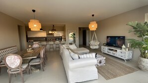 Un salon moderne avec un canapé, une table à manger et un téléviseur.