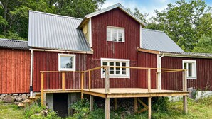 A red wooden house with a metal roof, a wooden deck, and a small window. - 3 bedroom cozy home in Jämshög (Jämshög)