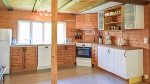 A kitchen with wooden cabinets, a stove, and a sink. - 3 bedroom cozy home in Jämshög (Jämshög)