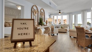 A spacious living room with a large window, a fireplace, and a sign that reads "YAY, YOU'RE HERE!". - Any day at the beach is a good day! 🏖️ Book your vacay today!  (Miramar Beach)