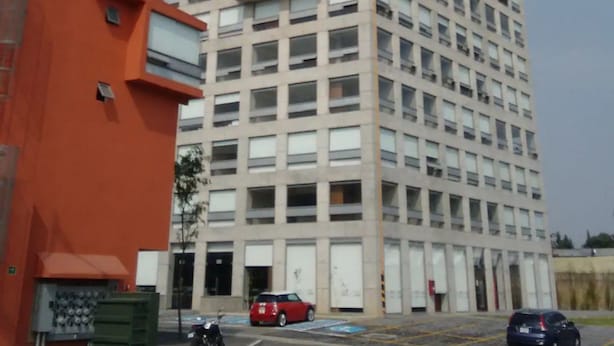 Um edifício alto e retangular com uma grade de janelas.