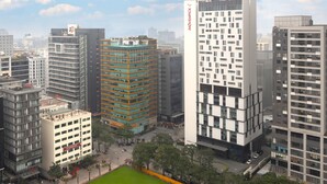 A high-rise building with a modern architectural design, featuring multiple floors and a prominent entrance.