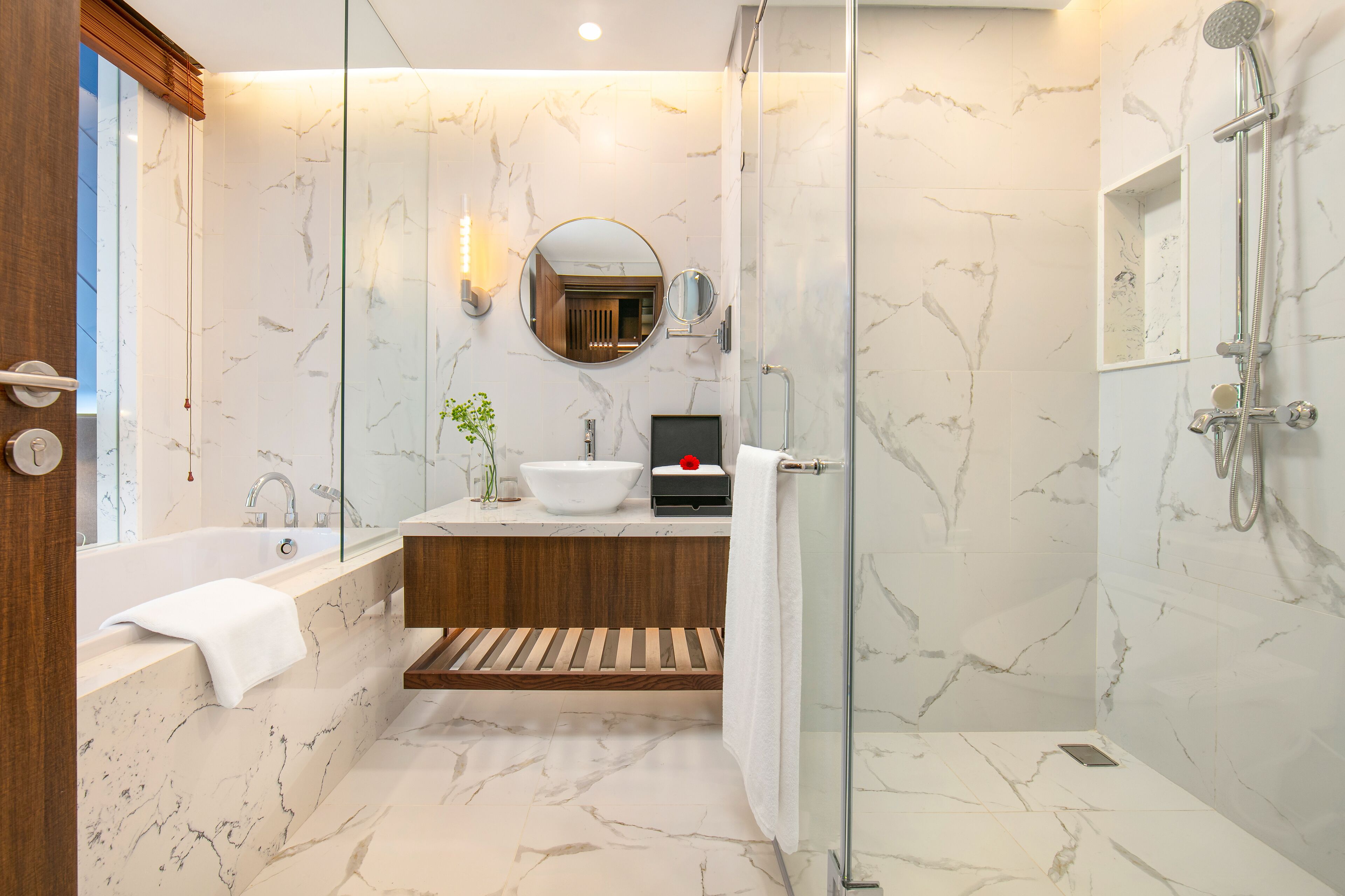 Une salle de bain moderne équipée d’une baignoire, d’un lavabo, d’un miroir et d’une douche.
