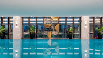Una piscina techada, sillones reclinables de piscina