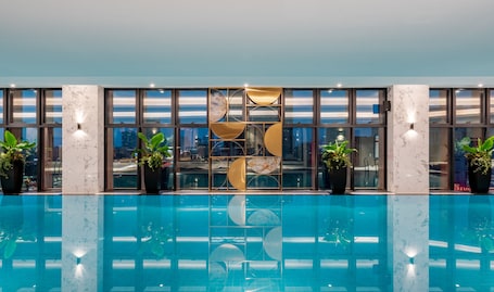 Una piscina techada, sillones reclinables de piscina