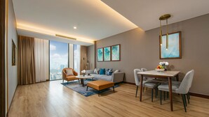 Una sala de estar moderna con sofá, sillones, una mesa de centro y una mesa de comedor con sillas.