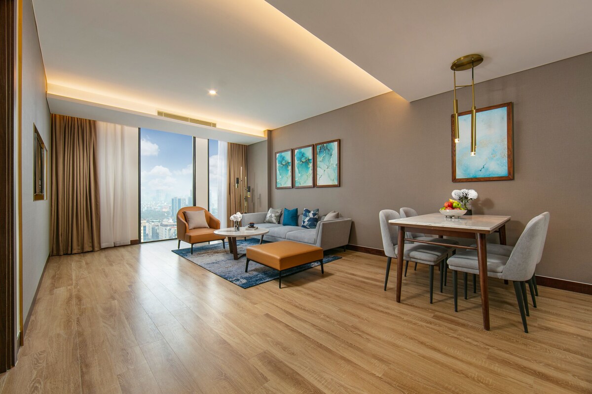 Un salon moderne comprenant un canapé, des fauteuils, une table basse et une table à manger avec des chaises.