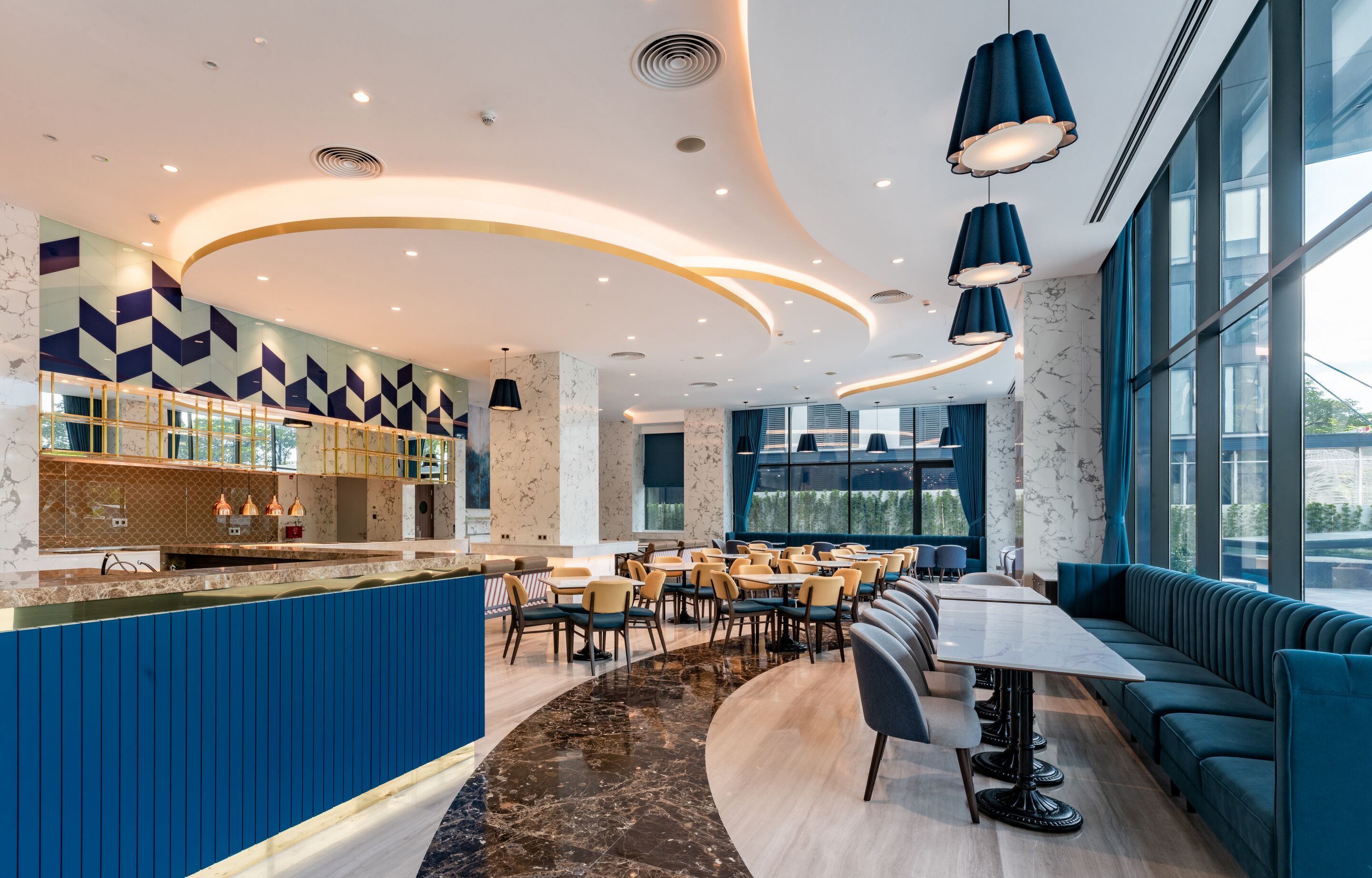 A modern restaurant with a bar, seating areas, and large windows.
