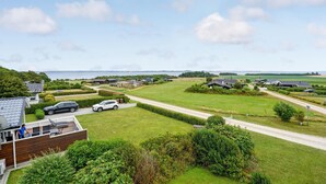 Ett bostadsområde med hus, en väg och utsikt över havet.