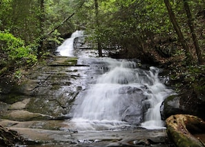 A waterfall cascading over rocks in a forested area.