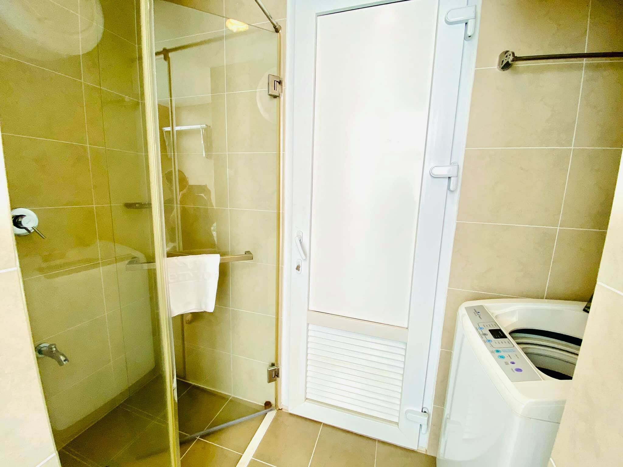 Een badkamer met een douchecabine van glas, een witte handdoek en een witte handdoekhouder.