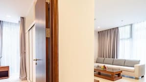 A modern living room with a sofa, coffee table, and a wooden door. - Glenwood Residences (Ho Chi Minh City)