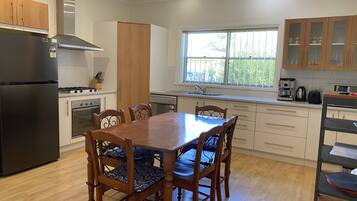 Enjoy cooking in this well-lit kitchen with a central island, refrigerator, oven, and gas stove.