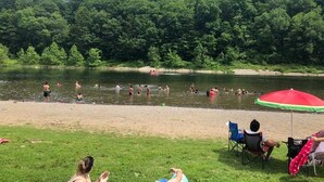 A lakeside scene with people swimming and relaxing on the shore. -  EL EDEN PLACE TO REST AND ENJOY (EL EDEN LUGAR PARA DESCANSAR Y DISFRUTAR  (Bushkill)