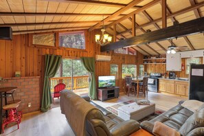 Un acogedor interior de cabaña con sala de estar, comedor y cocina.