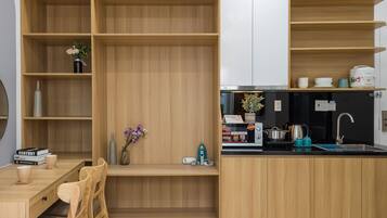 A modern kitchen with wooden cabinetry, a dining area with a table and chairs, and a built-in oven.