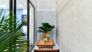 Eine Raumecke mit Holztisch und -stühlen, einem Blumentopf und einem Poster an der Wand.