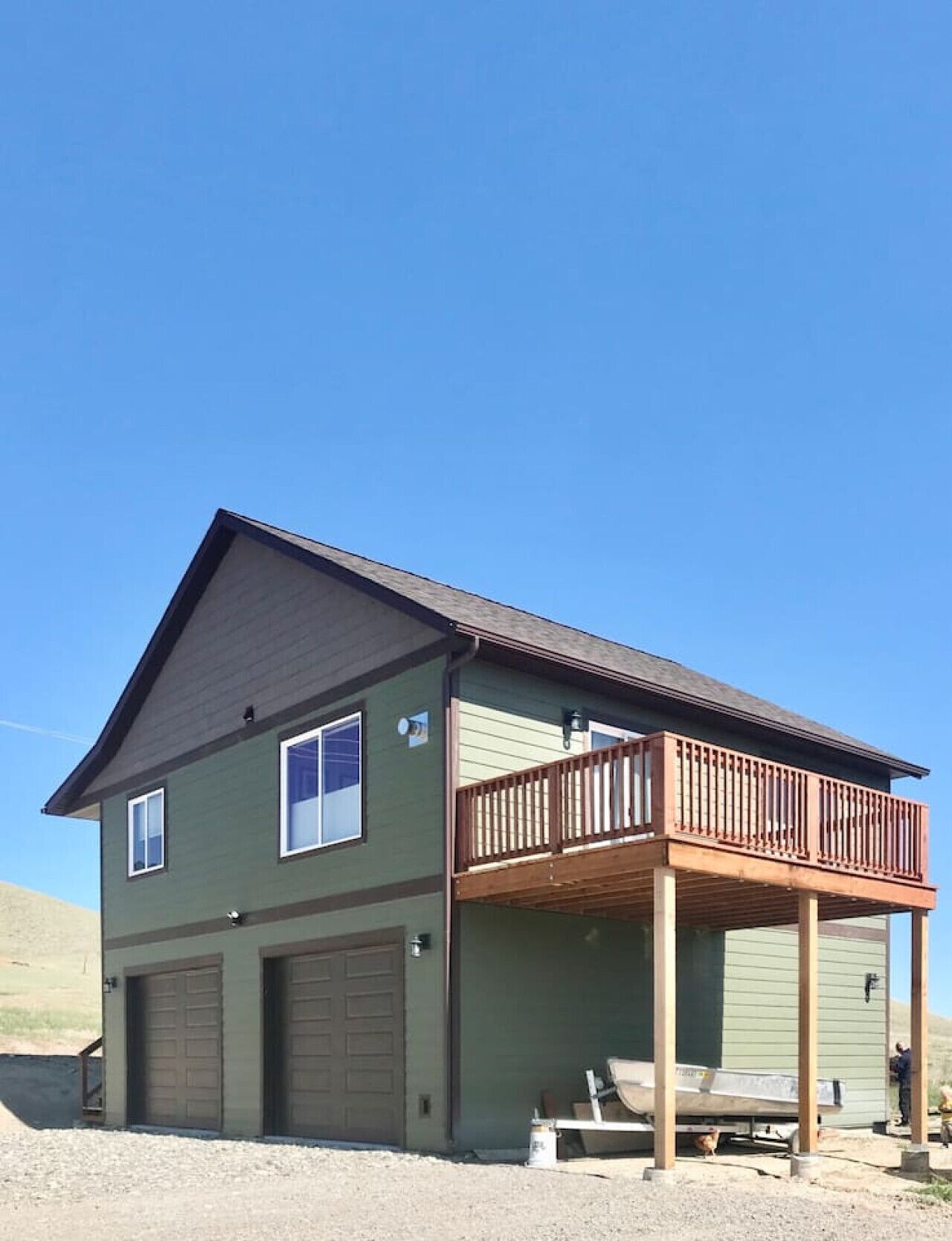 A two-story house with a balcony, a garage, and a small porch area.