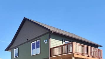 A two-story house with a balcony, a garage, and a small porch area.