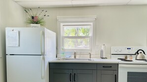Una cocina equipada con refrigerador, pileta, estufa y alacenas.