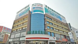 A multi-story commercial building with various storefronts on the ground floor, including a visible restaurant and a pharmacy. - Greentree Inn Linyi Yitang Town Shuangling Road Ex (Linyi)