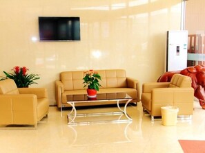 A modern lobby with a beige sofa set, a glass coffee table, and a red sculpture. - Greentree Inn Linyi Yitang Town Shuangling Road Ex (Linyi)