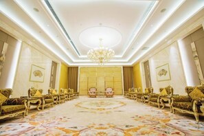 Une vaste pièce agrémentée d’un lustre, de meubles richement décorés et d’un tapis à motifs.