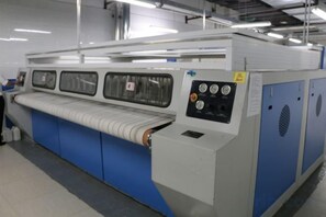 Une grande machine industrielle dotée de panneaux de commande et de hottes de ventilation.