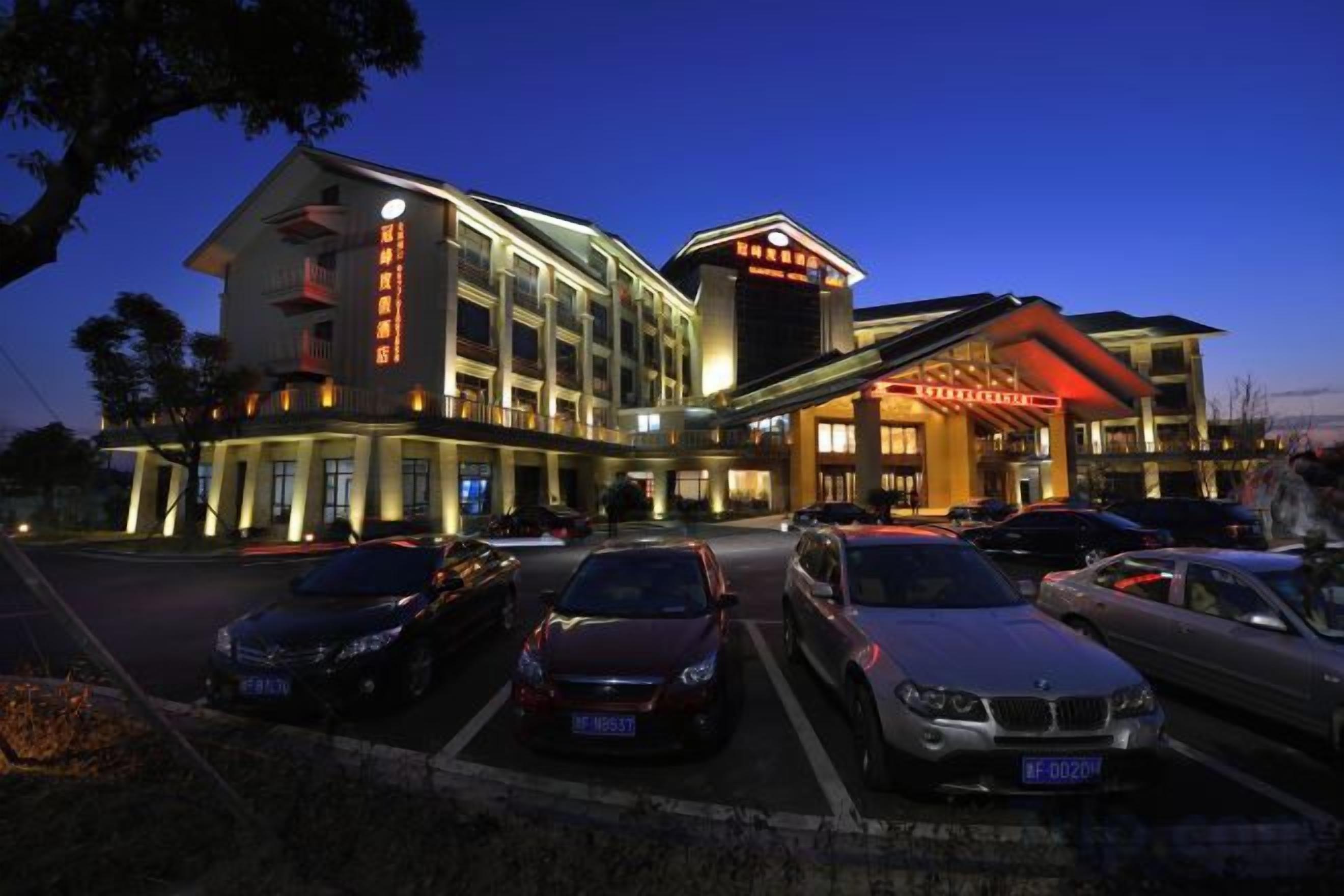A hotel with multiple parking spaces, a prominent entrance, and a large building facade.