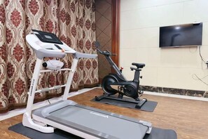 A home gym with a treadmill, elliptical, and stationary bike. - Guanfeng Holiday Hotel (Tongxiang)