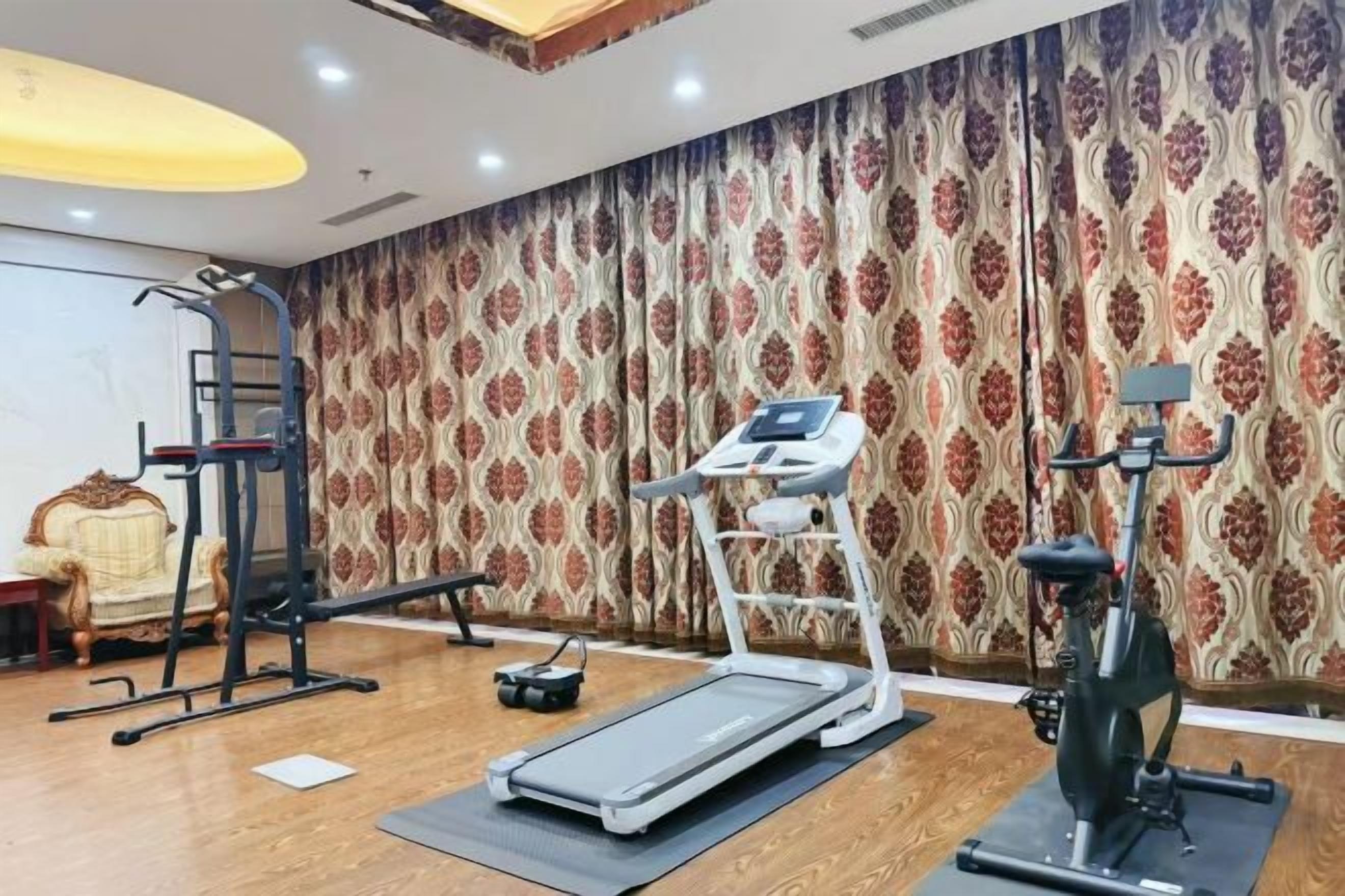 A gym with exercise equipment including a treadmill, elliptical, and stationary bike.