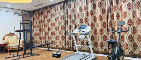 A gym with exercise equipment including a treadmill, elliptical, and stationary bike.