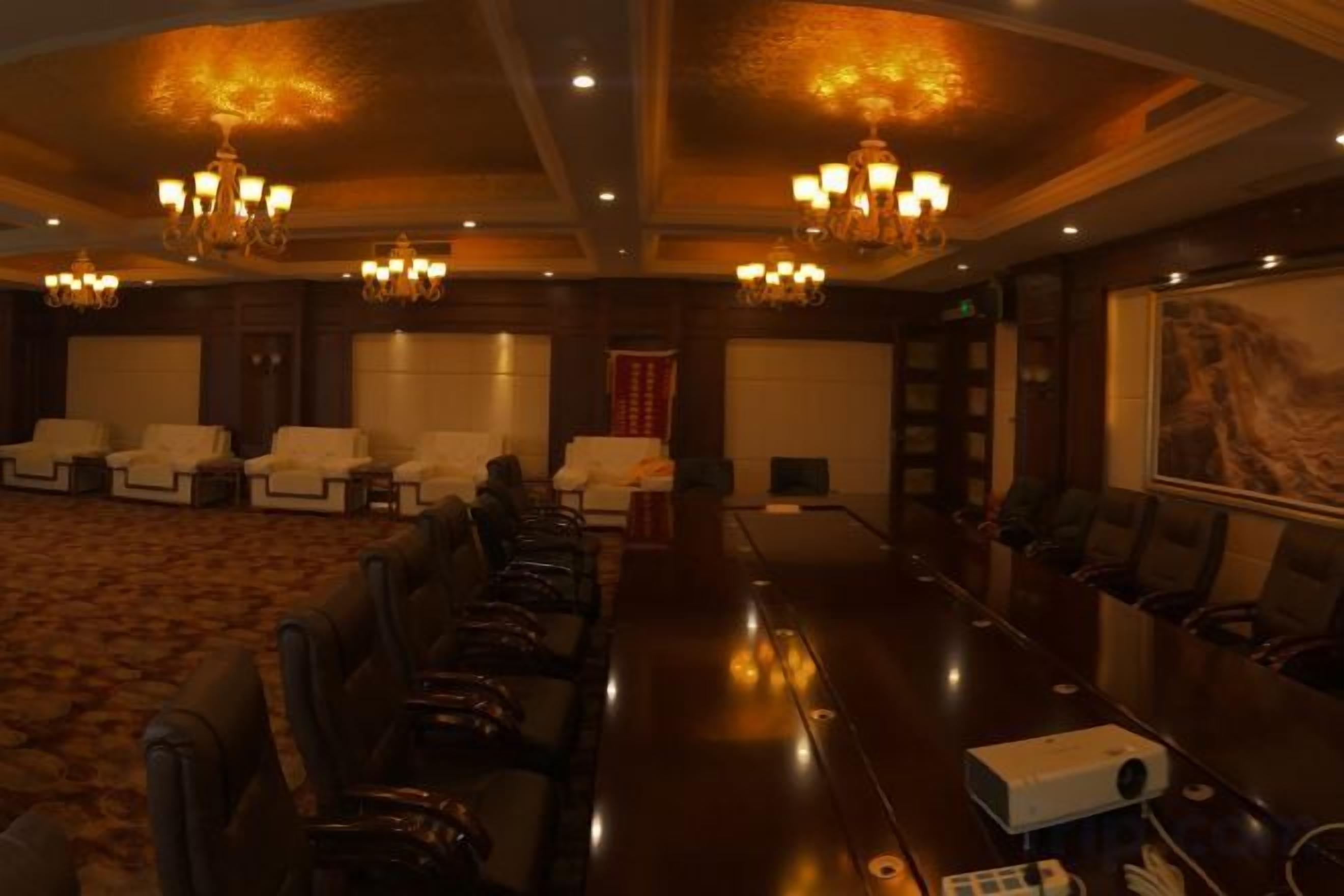 A conference room with a long table, multiple chairs, and a projector.