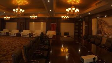 A conference room with a long table, multiple chairs, and a projector.