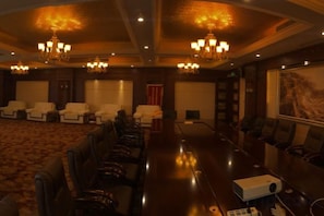 A conference room with a long table, multiple chairs, and a projector.