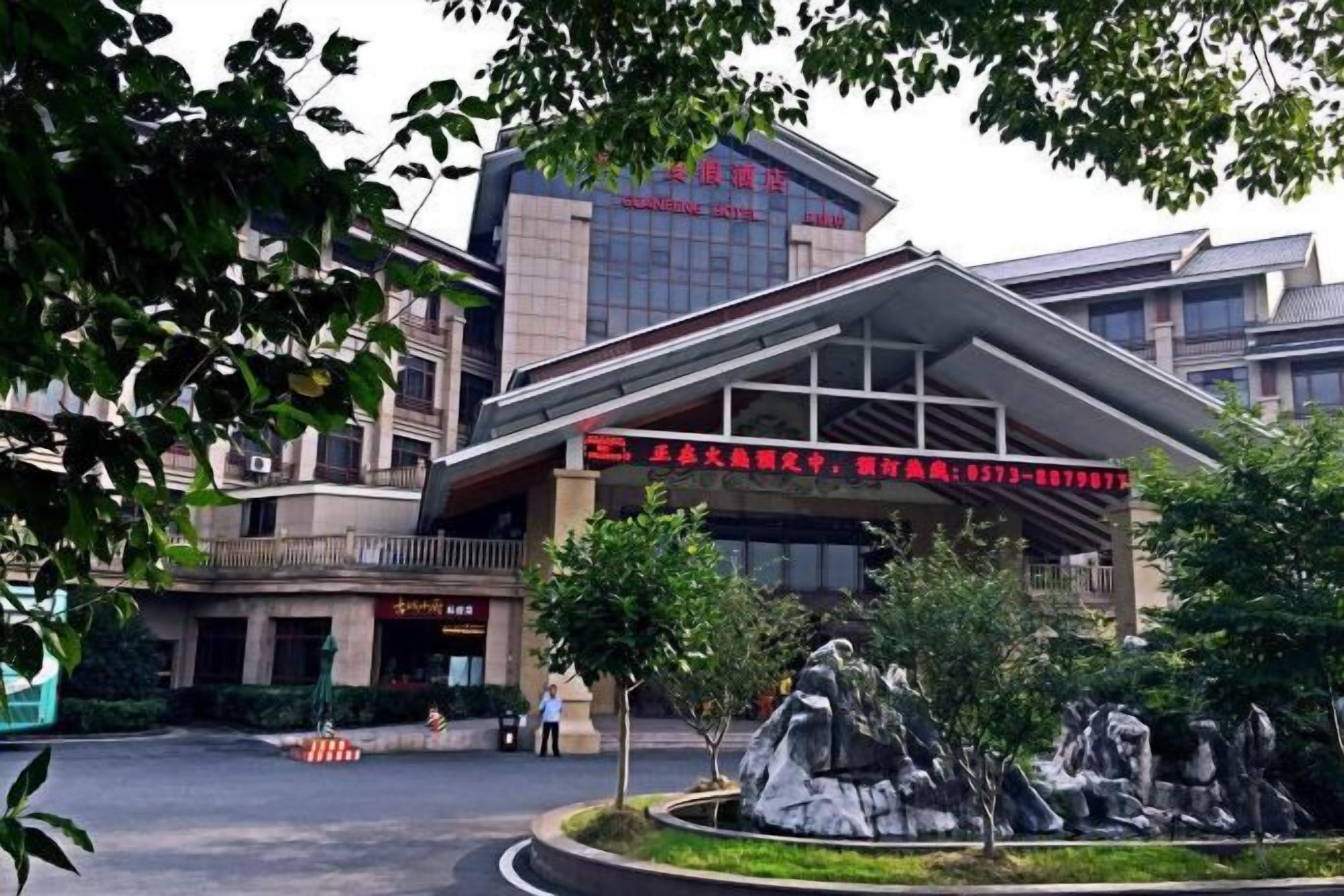 A building with a modern architectural design, featuring a prominent entrance with a red sign.