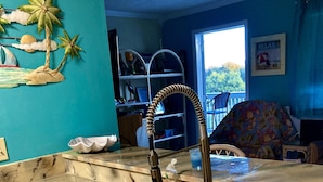 A kitchen with a sink, a faucet, and a dish rack.