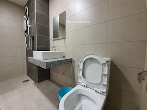 Bathroom features a granite countertop sink, toilet, and showerhead.