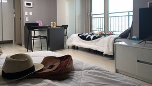 Une chambre d’hôtel avec un lit, un bureau, une chaise, une télévision et un balcon avec vue.