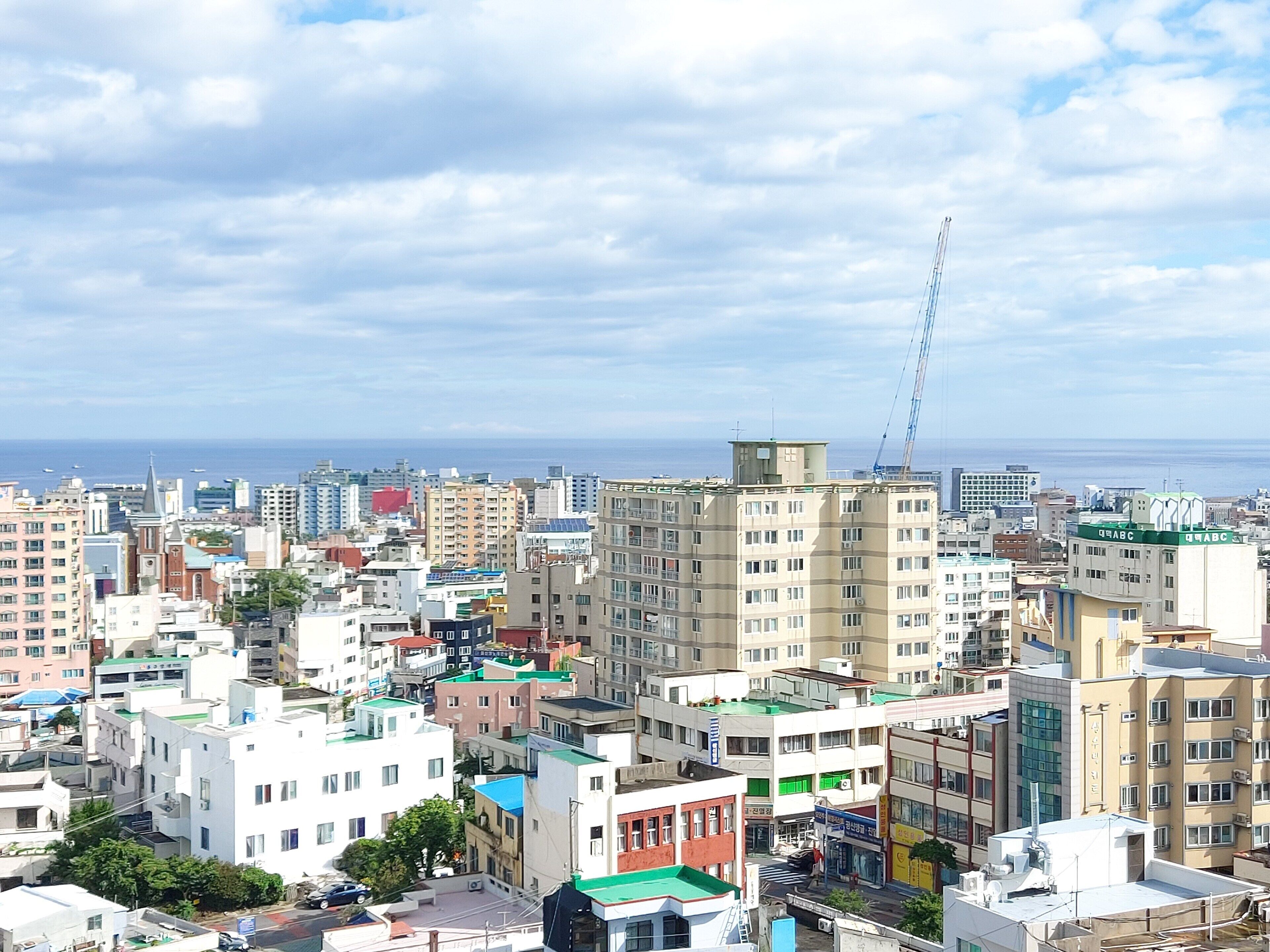 Un paisaje urbano con varios edificios, incluyendo una torre destacada y varias construcciones de varios pisos.