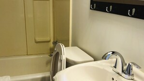 A bathroom with a toilet, sink, and bathtub.