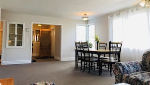 A spacious living room with a dining area, a sofa, and a glass coffee table.