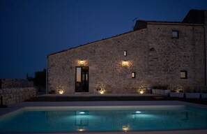 A stone building with a pool, a door, and exterior lighting. - Mazar, Masseria with a private heated pool* (Ragusa)